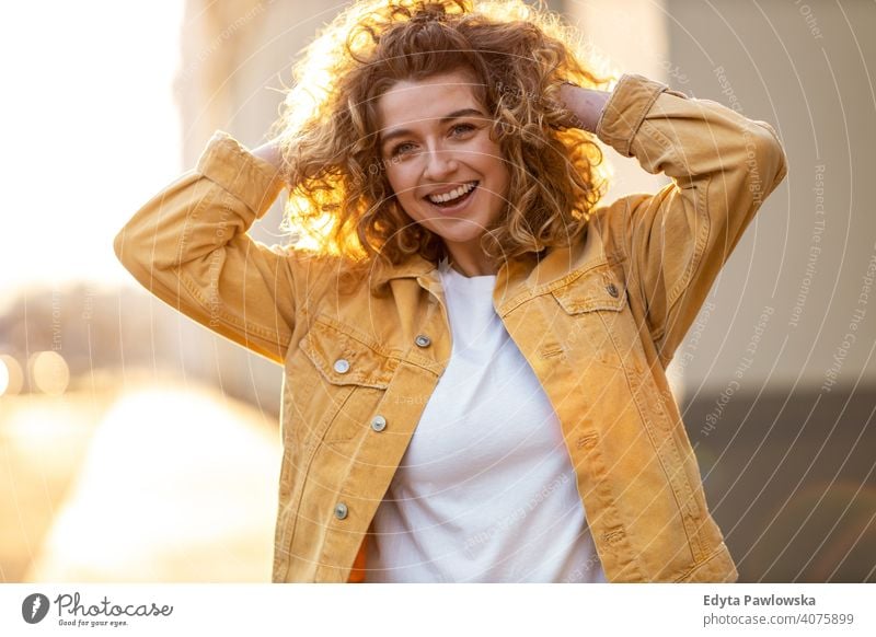 Porträt einer jungen Frau mit lockigem Haar in der Stadt natürlich Sonnenlicht urban Großstadt Hipster stylisch positiv sonnig cool Afro-Look Freude Gesundheit