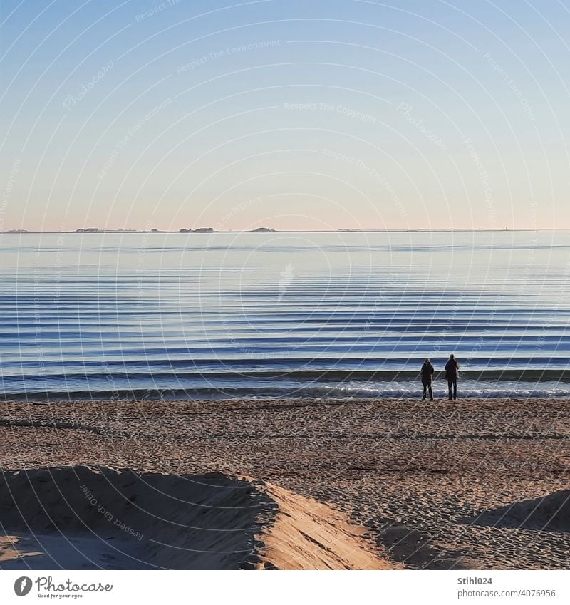 Paar am Strand von Föhr mit Blick auf die Halligen Sandstrand Wellen Wellengang Dünung sanft gekräuselt Wasser Ostsee Nordsee Insel Horizont