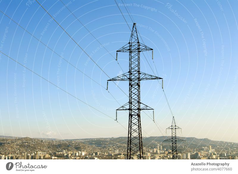 Strommasten mit einem Stadtbild. blau Business Kabel Zivilisation aktuell Gefahr Design Verteilung Ökologie elektrisch Elektrizität Energie Maschinenbau Umwelt