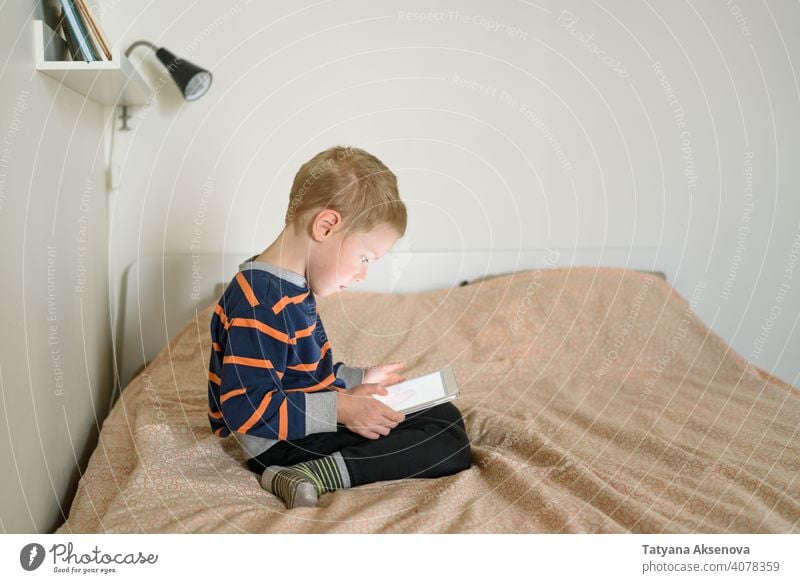 Junge mit Tablette auf dem Bett Kind Internet Technik & Technologie Lernen modern heimwärts digital Freizeit Bildung digitales Tablett Mitteilung Kindheit