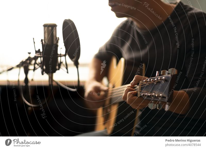 Mann spielt spanische Gitarre und singt, während er sie mit einem Mikrofon aufnimmt Musical Instrument Spanisch Musik männlich Person Gesang Menschen spielen