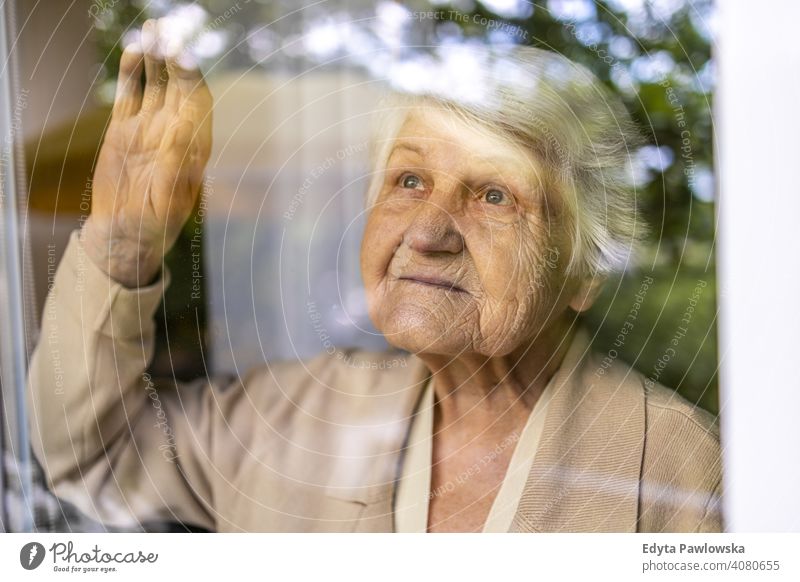Ältere Frau schaut aus dem Fenster zu Hause traurig einsam unglücklich Depression Unsicherheit Angst beunruhigt Trauer Traurigkeit Verlust Problematik Krise