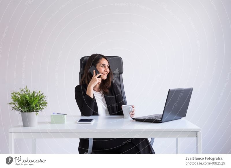 schöne junge Business-Frau mit seinem Laptop im Büro und sprechen über ihr Handy. Business Concept.white Hintergründe. Drinnen Computer Arbeiter Geschäftsfrau