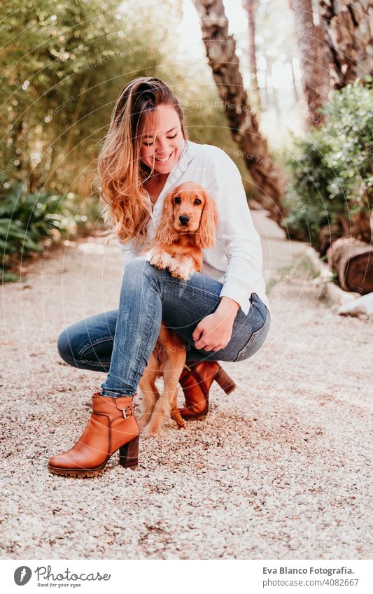 junge Frau und ihr niedlicher Cockerspaniel-Welpe im Freien in einem Park Hund Haustier sonnig Liebe Umarmung Lächeln Kuss züchten Reinrassig schön blond braun
