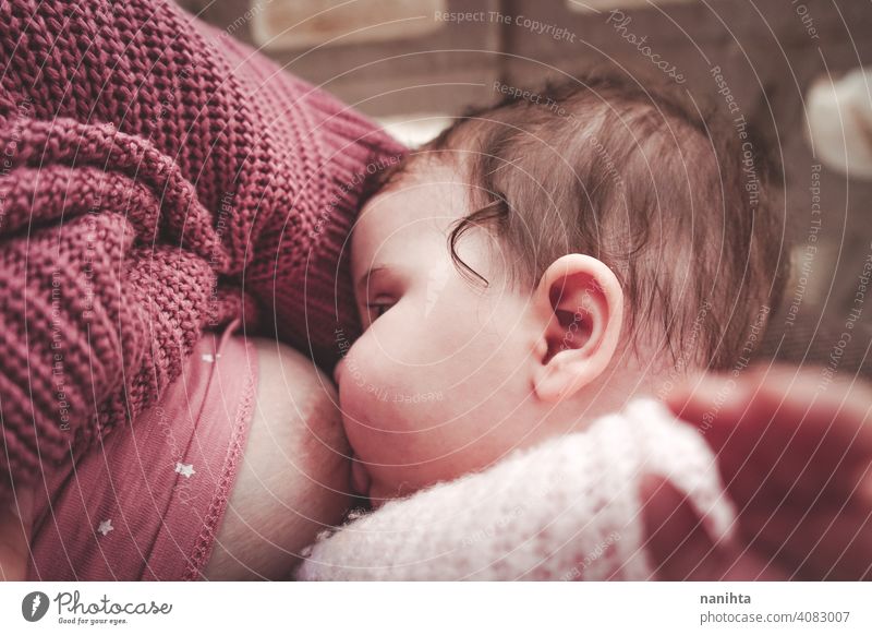 Junge Frau, die ihr Baby stillt Stillen Mama Mutterschaft Familie Exklusivität Kindheit neugeboren rosa warm gemütlich natürlich wirklich Leben realistisch