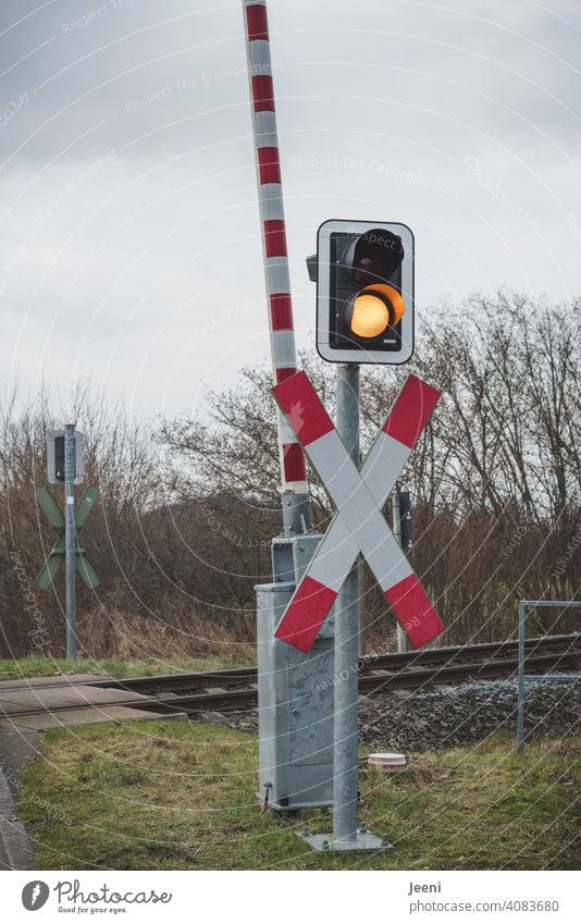 Auch wenn die Signalfarbe gelb anzeigt, muss man an den Bahnschienen warten Bahnschranke Schranke Bahnübergang Andreaskreuz Warnung Achtung Überqueren