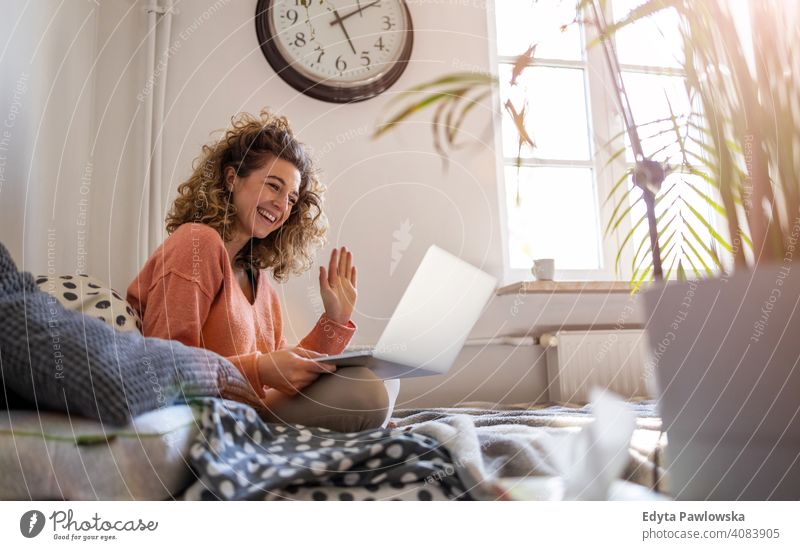 Junge Frau arbeitet im Bett zu Hause mit Laptop Bildung Lernen studierend Hausaufgabe Buch E-Learning Technik & Technologie Computer arbeiten Internet online