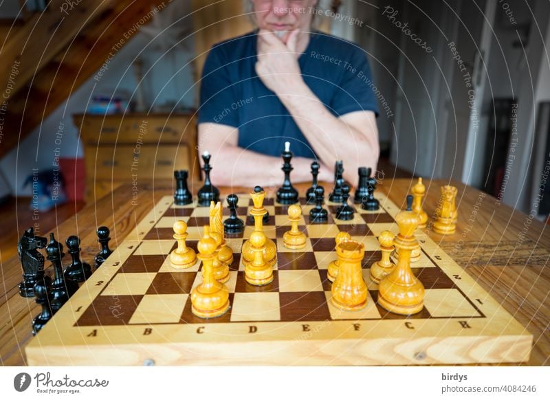 Schachspieler in nachdenklicher Pose vor einem Schachbrett Schachfiguren nachdenken überlegen Konzentration Brettspiel Gegner Schachpartie Spielen Denken
