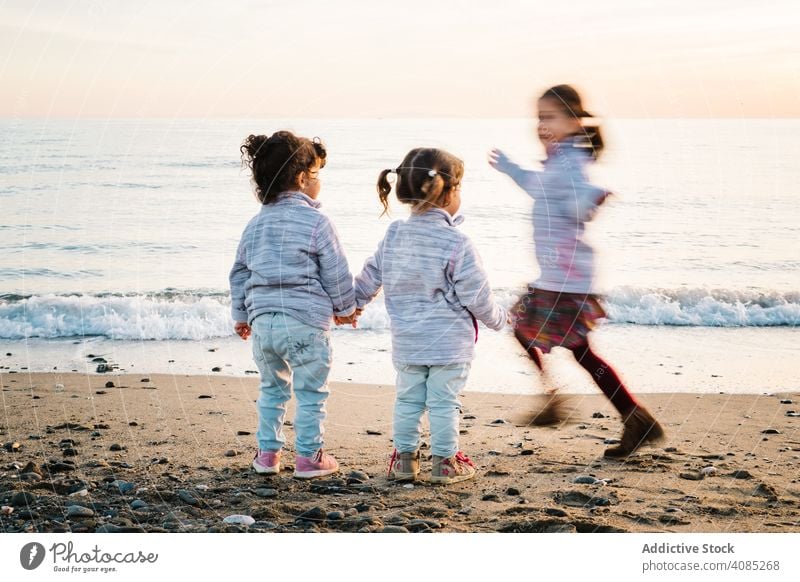 Kinder spielen am Strand rennen Spaß Händchenhalten MEER Schwester Freude Mädchen Freunde Spielen Kindheit drei jung Sand Winter Junge Glück Lifestyle Urlaub