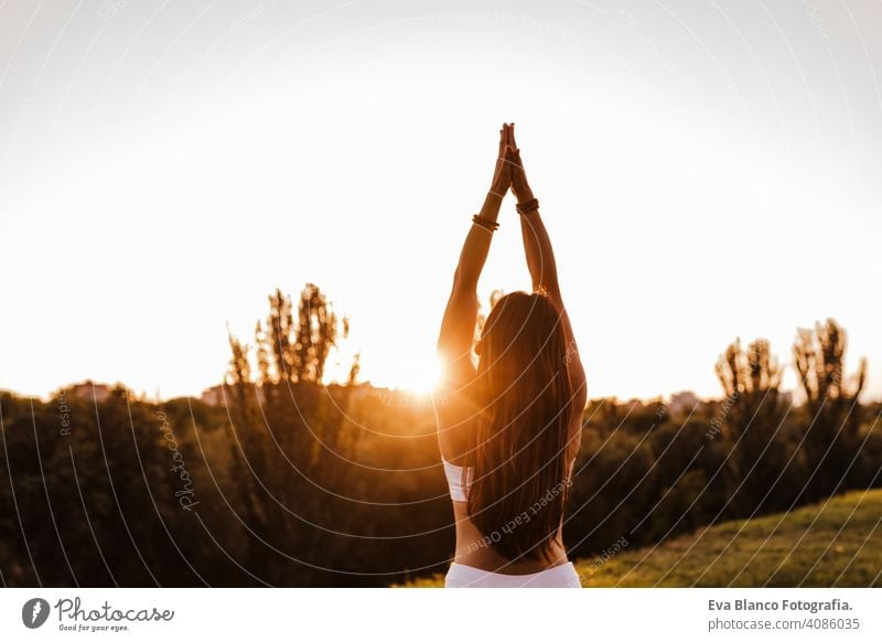 junge schöne asiatische Frau macht Yoga in einem Park bei Sonnenuntergang. Yoga und gesunder Lebensstil Konzept Sommer Glück Genuss Sport Lifestyle sportlich