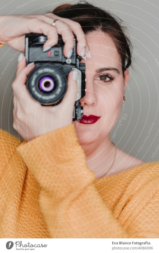 Nahaufnahme Porträt einer jungen Frau, die eine Kamera hält. Fotografie Konzept lässig attraktiv Glück Paparazzi professionell Linse modern Kunst Lifestyle