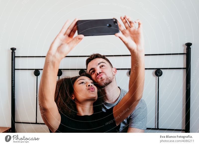 glückliches Paar in der Liebe zu Hause. Afroamerikanische Frau und kaukasischen Mann ein Selfie mit Handy nehmen. ethnische Liebe Konzept Afroamerikaner
