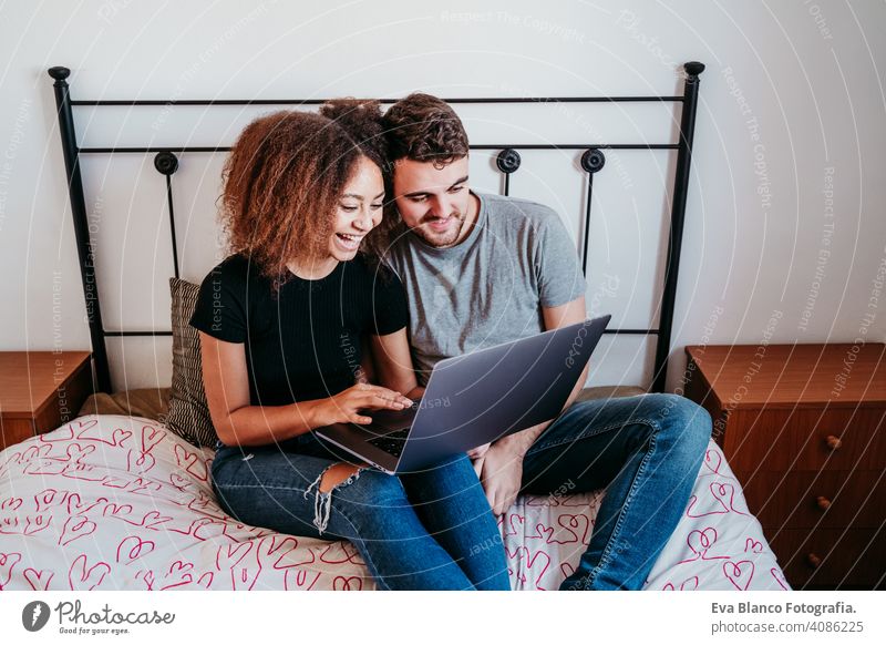 glückliches Paar in der Liebe zu Hause. Afroamerikanische Frau und kaukasischen Mann mit Laptop. ethnische Liebe Konzept Technik & Technologie Afroamerikaner