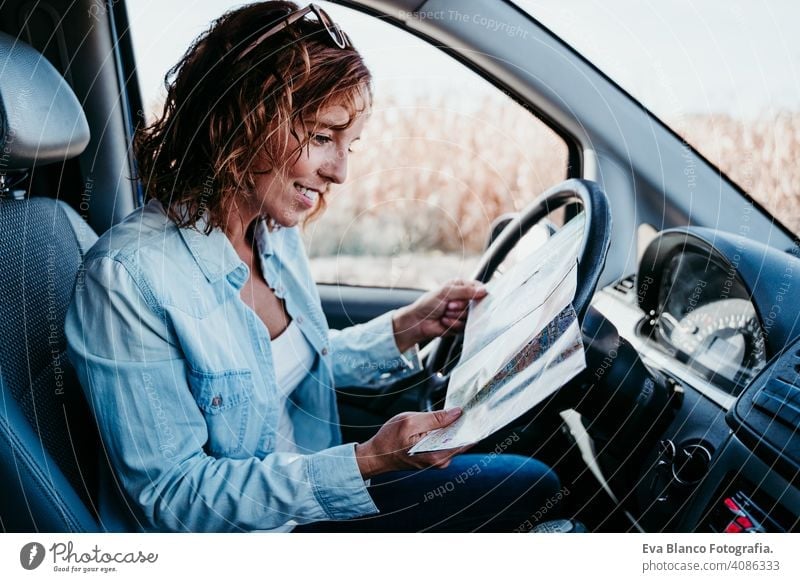junge schöne Frau lesen eine Karte in einem Auto. Reise-Konzept Landkarte fahren PKW sonnig Sonnenbrille reisen reisend Rad Laufwerk mieten Teilen neu Verkehr