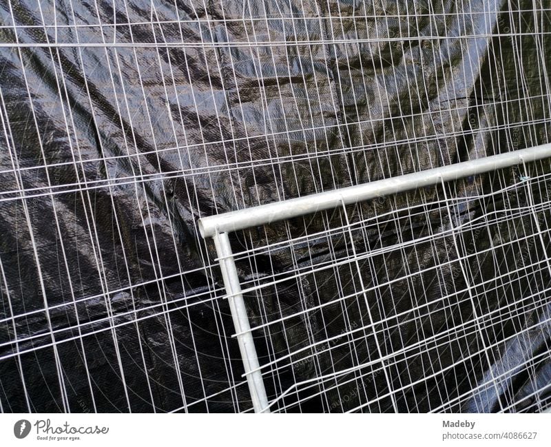 Bauzaun mit grauem Drahtgeflecht und schwarzer Sichtschutz aus Kunststoff auf einer Baustelle am Campus der Goethe Universität in Frankfurt am Main Bockenheim in Hessen