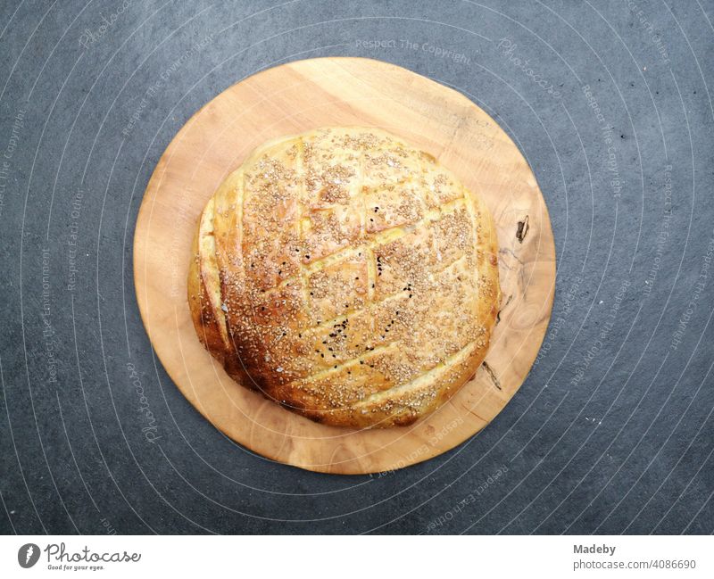 Leckeres selbstgemachten Fladenbrot auf rundem Holzteller auf einem grauen Betonboden in der Designerwohnung eines alten Bauernhaus in Rudersau bei Rottenbuch im Kreis Weilheim-Schongau in Oberbayern