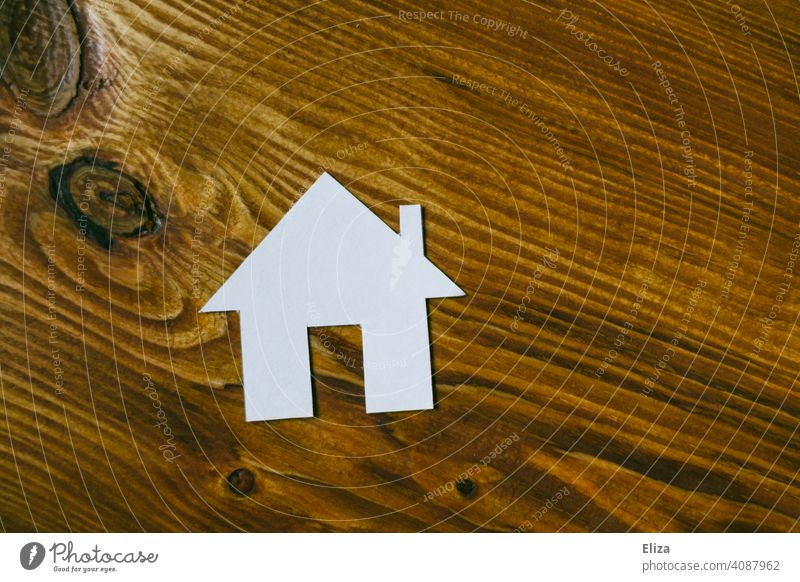 Weißes Haus aus Papier auf Holz. Eigenheim und Hausbau. Zuhause Traumhaus Haus bauen häuslich Immobilie immobilien Gebäude wohnen zuhause