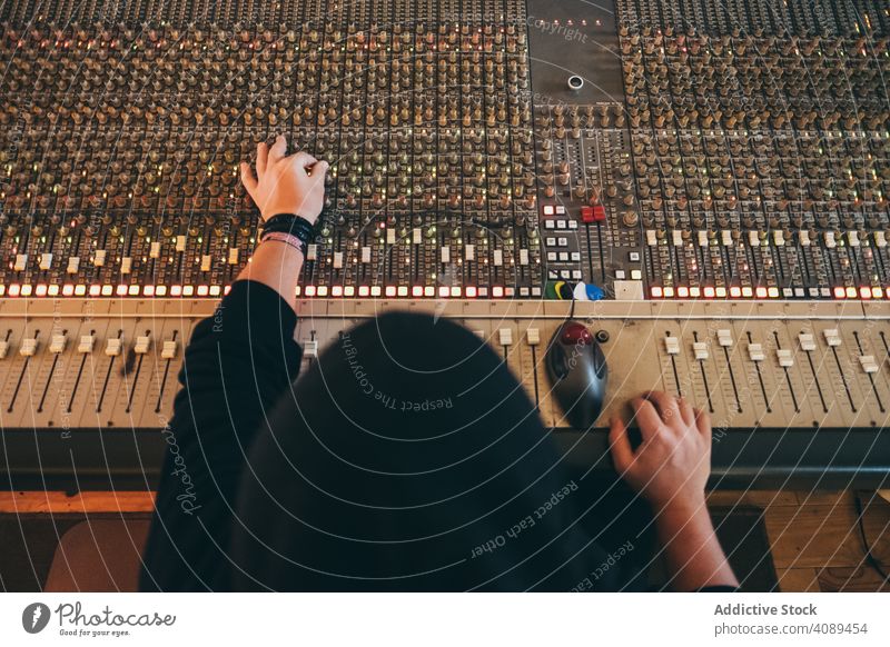 Mann an einem Equalizer-Instrument in einem Studio Spielen akustisch Musiker spielen Klang Einsteller Resonanzboden Inszenierung Knöpfe Radio Komponist Atelier