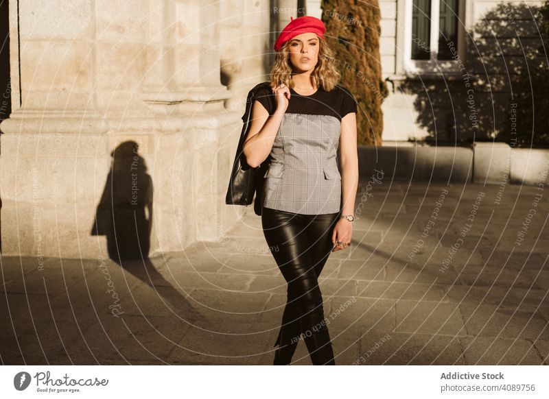 Stilvolle weibliche stehend in der Nähe von Gebäude Wand Frau stylisch Straße Großstadt in die Kamera schauen sinnlich sonnig tagsüber Lederjacke Baskenmütze