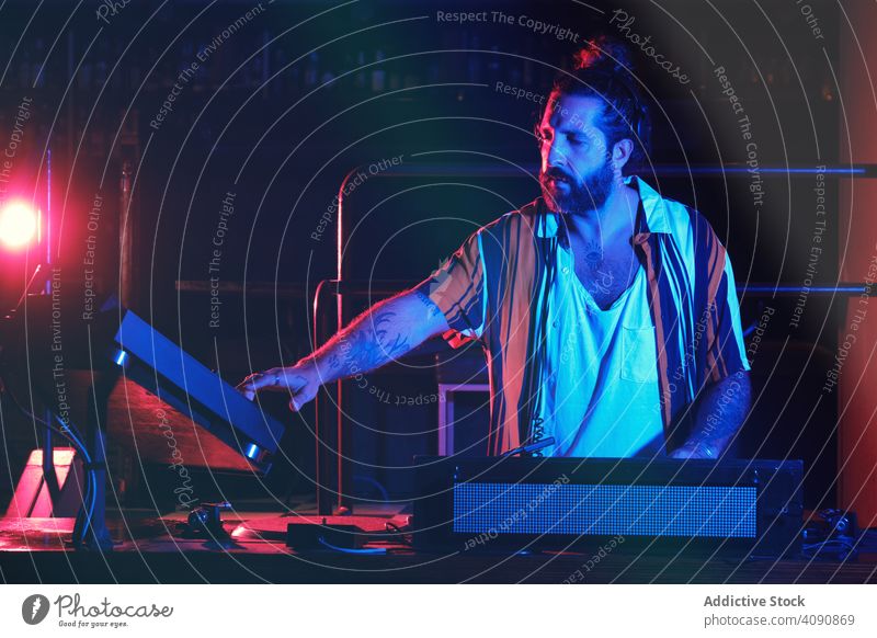 Bärtiger Dj Mann spielt Disco-Musik in einem Club Elektronik Diskothek Menge Lautstärke professionell Audio zeigen Mixer stereo Geräusche Scheitel Kopfhörer