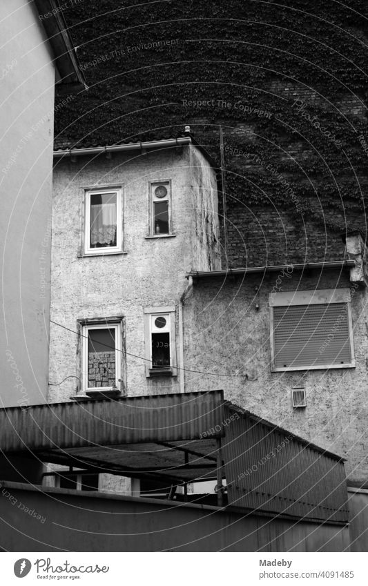 Verwahrlostes Wohnhaus mit alten Gardinen und heruntergelassenem Rollladen im Mathildenviertel in Frankfurt am Main in Hessen, fotografiert in neorealistischem Schwarzweiß
