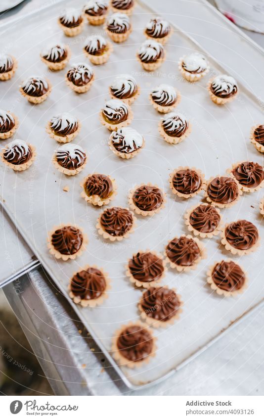 Tablett mit schweineförmigen Desserts in der Bäckerei Gebäck Schwein Ablage Form Symbol klein rosa Kuchen Ohr Schnauze Lebensmittel süß frisch backen