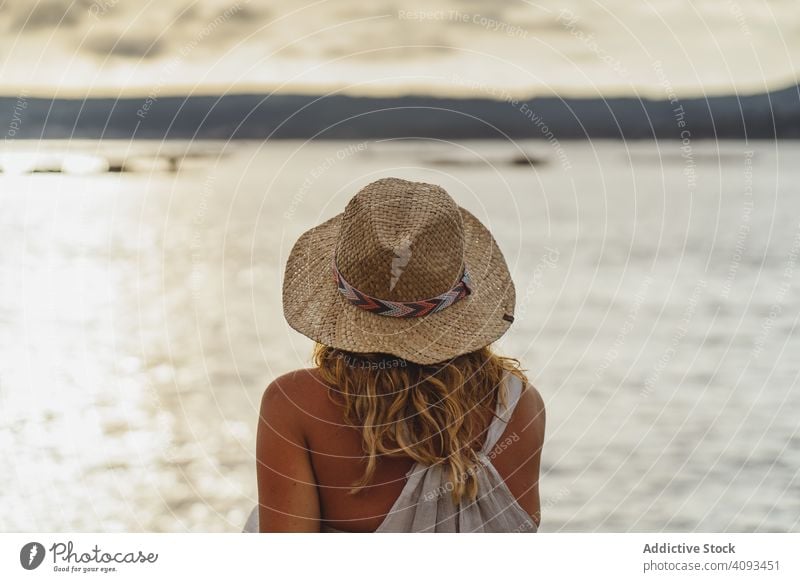 Blonde Frau ruht sich am Meer aus Meereslandschaft Küste malerisch Harmonie Cloud Einsamkeit Frieden genießen reisen Seeküste Windstille ruhig Hut Ausflug