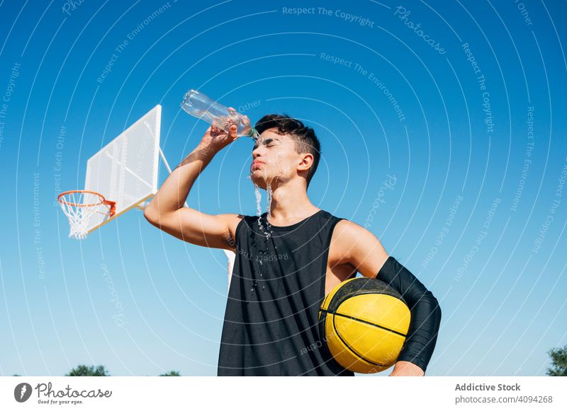 Junger Mann steht mit Ball und spielt auf Basketballplatz im Freien. Athlet Konkurrenz Sportgerät Erwachsener Erholung Aktion Porträt aktiv Aktivität Asphalt