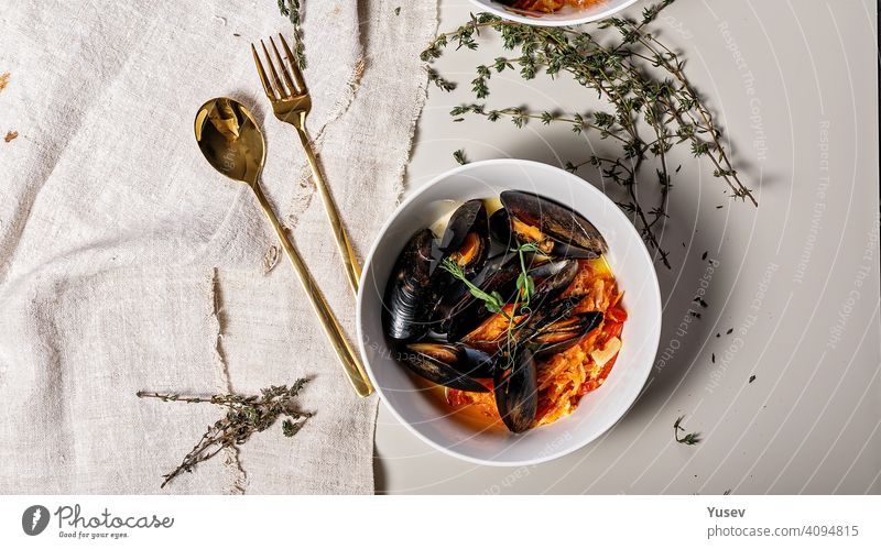 Lebensmittel-Banner. Eine Portion Muscheln mit Gemüse in einer weißen Schüssel auf einem hellen Hintergrund. Leckere und gesunde Meeresfrüchte. Schalentiere. Ansicht von oben