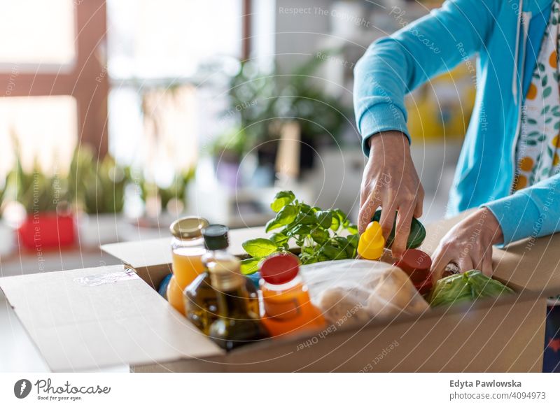 Frau beim Auspacken einer Kiste mit Lebensmitteln zu Hause Supermarkt Markt Laden Frucht Gemüse Gesundheit Lebensmittelgeschäft organisch frisch Küche Diät