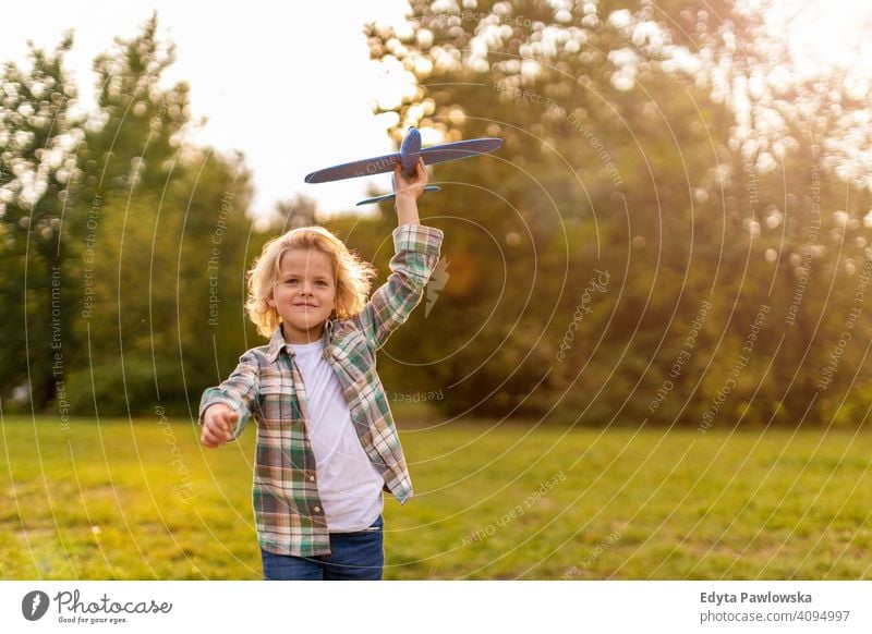 Kleiner Junge spielt mit Spielzeug Flugzeug im Park Menschen Kind kleiner Junge Kinder Kindheit im Freien lässig niedlich schön Porträt Lifestyle elementar