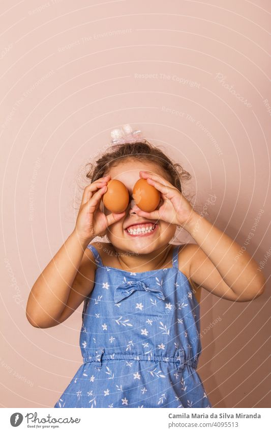Lächelndes Kind hält zwei Eier. Hintergrund schön Hase Kaukasier feiern Feier farbenfroh Textfreiraum niedlich Ohren Ostern Spaß lustig Mädchen Glück Feiertag