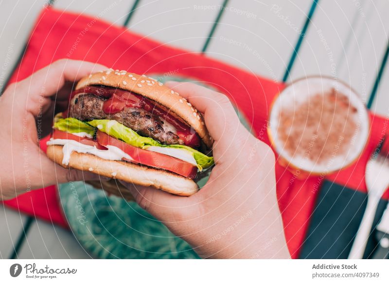 Hände halten einen Cheeseburger mit Salat und Tomate Burger Brötchen klassisch ungesund Tisch Lebensmittel Mahlzeit Zwiebel Rindfleisch lecker grillen Grillrost