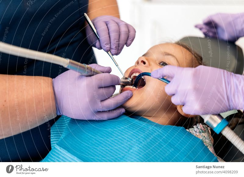 Junges Mädchen beim Checkup beim Zahnarzt Reinigen Dentalwerkzeuge Untersuchen Vorderansicht Kind jung aufschauend Klinik Dentalklinik geduldig Lügen Gesundheit