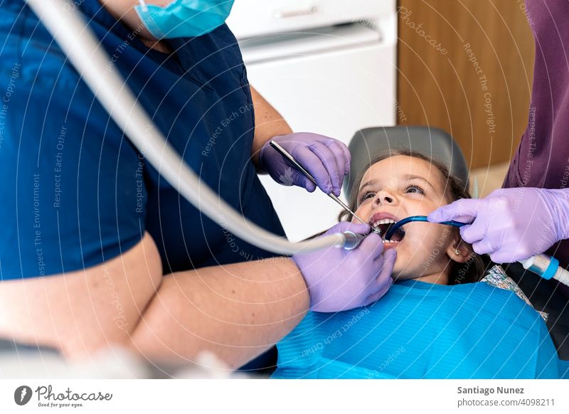 Junges Mädchen in Zahnarzt Reinigen Dentalwerkzeuge Untersuchen Vorderansicht Kind jung aufschauend Klinik Dentalklinik geduldig Lügen Gesundheit Pflege Gerät