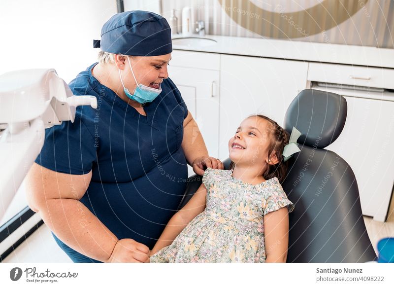 Zahnklinik Arbeiter und kleines Mädchen lächelnd die sich gegenseitig ansehen Frau geduldig Dentalklinik Lächeln Zwei Personen Vorderansicht Stehen Blick Kind