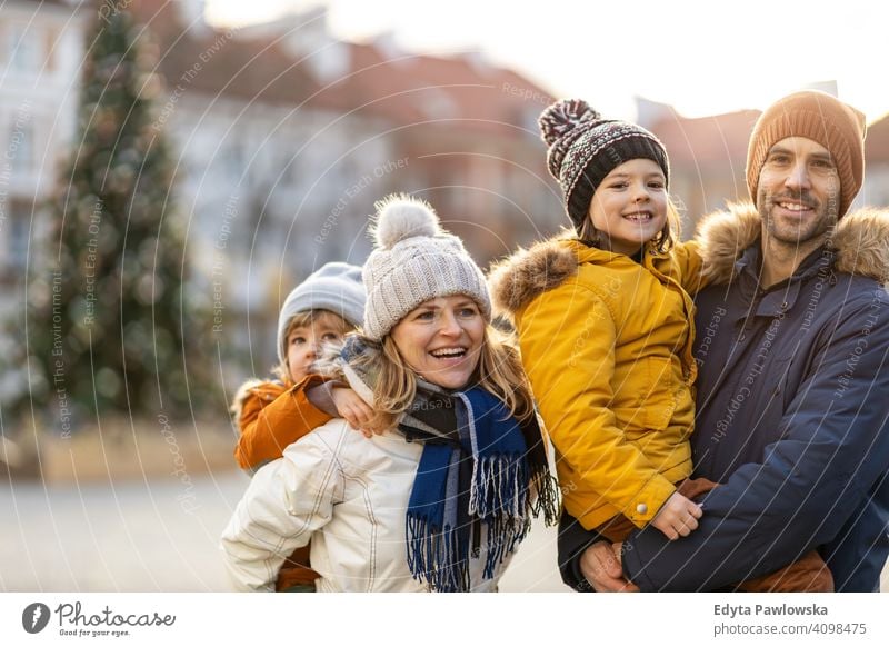 Glückliche junge Familie mit Spaß im Freien während Weihnachten Winter Mann Herbst Vater Frau Mutter Eltern Verwandte Sohn Jungen Kinder Partnerschaft