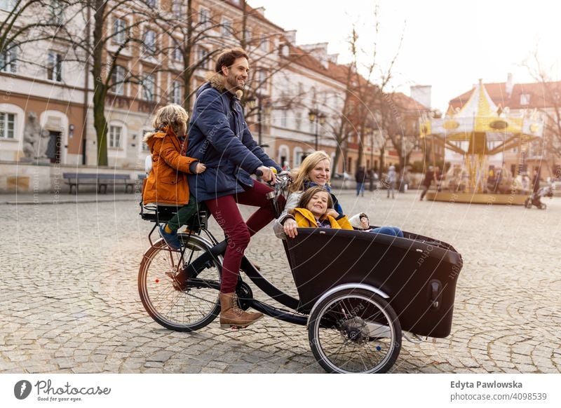 Junge Familie fahren in einem Lastenfahrrad zusammen Lastenrad Fahrrad Fahrradfahren Verkehr Dreirad Gesundheit aktiv Zyklus Radfahren modern