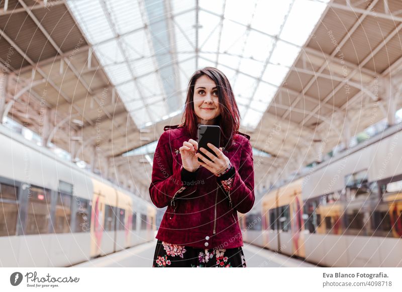 schöne kaukasische Frau im Bahnhof bereit zu reisen mit Handy. Reisen und Lifestyle-Konzept Technik & Technologie Smartphone Internet Gerät Verbindungen