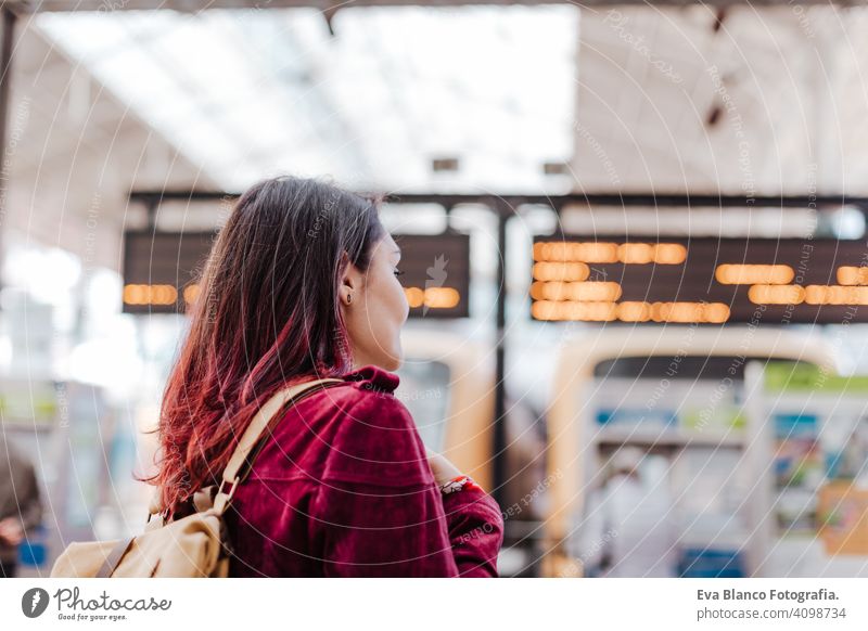 Rückenansicht von Backpacker Frau im Bahnhof warten zu reisen. Reisen und Lifestyle-Konzept Großstadt öffentlicher Verkehr Tafeln Kaukasier jung Ausflug