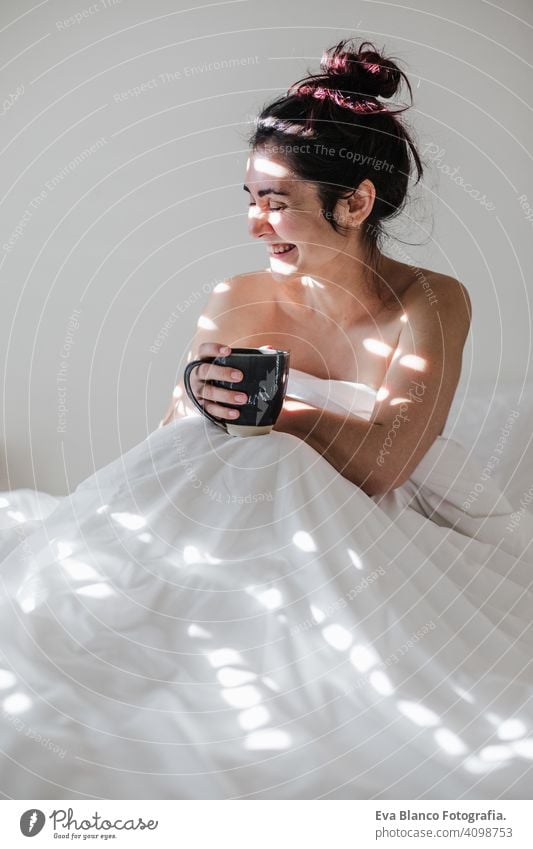 attraktive junge kaukasische Frau entspannt gut im Bett während der Morgenzeit. Dame genießt Tasse Kaffee im Schlafzimmer Frühstück trinken Getränk heiß Tee