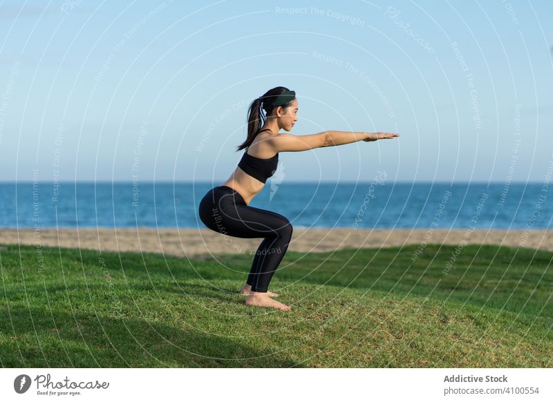 Frau beim Yoga am Strand üben Gras grün MEER Meer stehen Übung Gleichgewicht Training jung Athlet aktiv Windstille Ruhe Sportbekleidung Körper Fitness