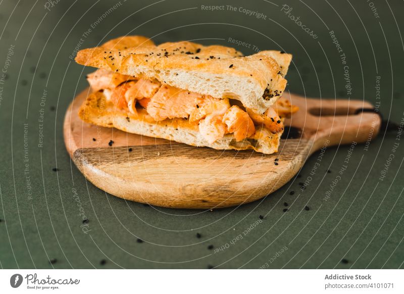 Fladenbrot auf Holzbrettchen Brot Belegtes Brot Holzplatte Sesam flach schwarz Schneidebrett rund Hähnchen Snack Lebensmittel Ernährung frisch Mahlzeit