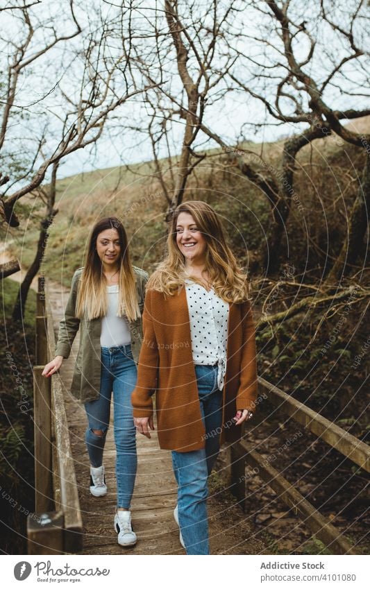 Frauen, die an einem Frühlingstag auf einem Holzsteg spazieren gehen Spaziergang Brücke Landschaft erkunden heiter hölzern Zusammensein Glück Schwester Steg
