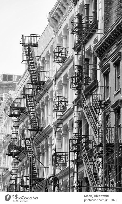 Reihe von alten Gebäude mit Eisen Feuerleitern, schwarz-weiß Bild von New York Stadtlandschaft, USA. New York State Manhattan Feuertreppe schwarz auf weiß