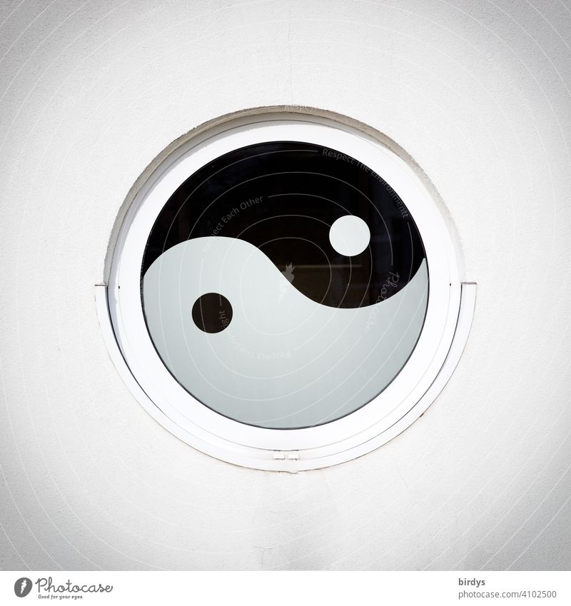 Yin und Yang, asiatisches spirituelles Zeichen der Verbindung von Dualität als rundes Fenster in einer Hauswand Spiritualität kreisrund Symbole & Metaphern