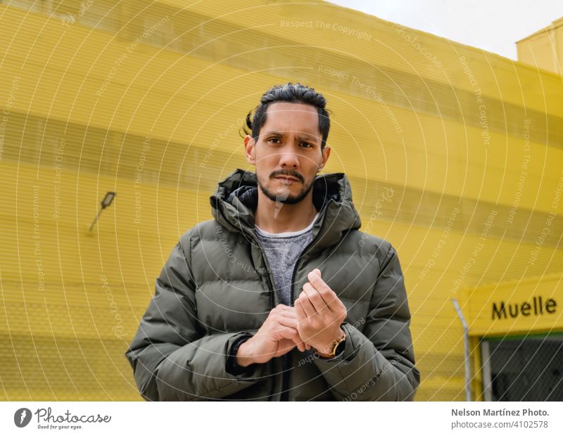 Porträt eines hispanischen Mannes vor einem gelben Hintergrund lokales Geschäft Sonnenlicht Tag Business eine Person Hispanische Ethnizität selbstbewusst