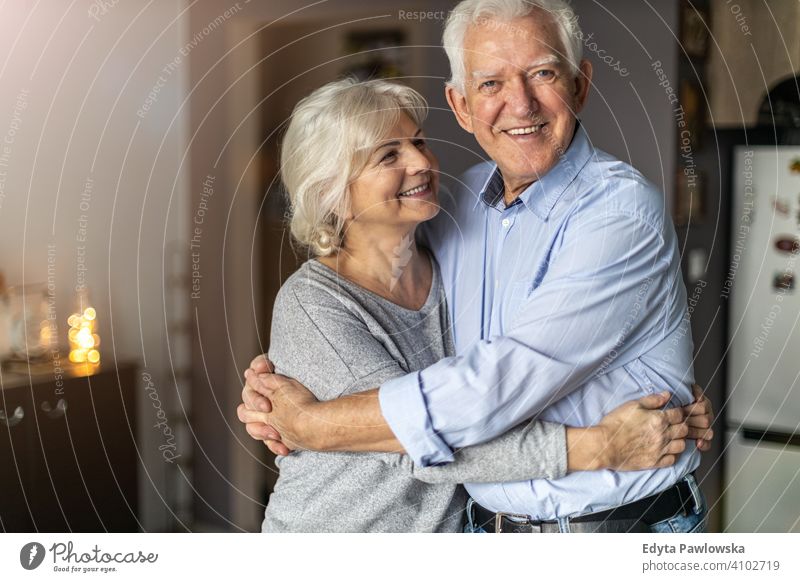 Glückliches älteres Paar, das sich in seinem Haus umarmt Frau Liebe Menschen Zusammensein zwei Senior reif Rentnerinnen Mann Zusammengehörigkeitsgefühl