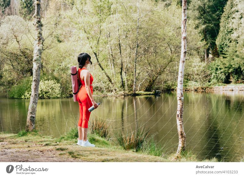 Junge Frau in Fitness-Kleidung im Park mit einer Yoga-Matte und eine Flasche Wasser mit Kopie Platz Forstwirtschaft Menschen trainiert. horizontal Training