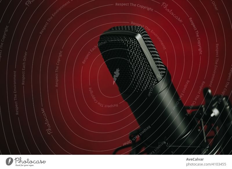 Eine Nahaufnahme eines strömenden Mikrofons über einem roten Hintergrund mit Kopierraum Aufzeichnen Audio Technik & Technologie Musik professionell Klang Radio